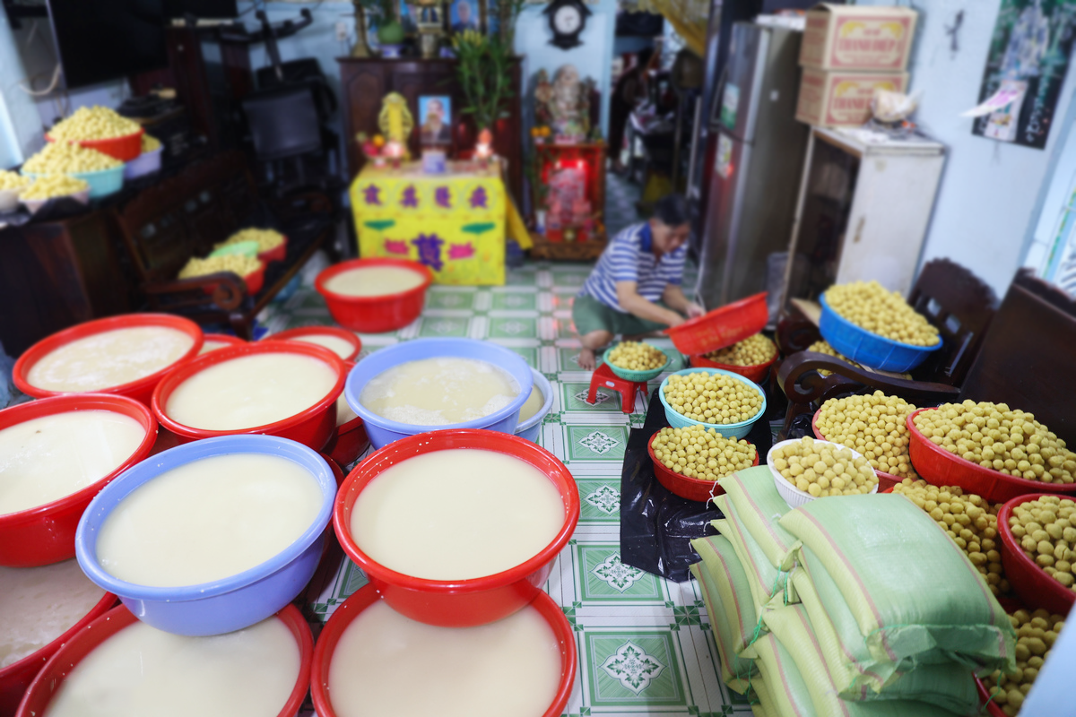 Tại một cơ sở sản xuất lâu năm trong xóm, gia đình ông Nguyễn Văn Trí chuẩn bị gần 900 kg gạo nếp cùng khoảng 150 kg đậu xanh để phục vụ mùa bánh năm nay. Với lượng nguyên liệu này, gia đình dự kiến làm khoảng 17.000 chiếc bánh ú cung cấp cho các chợ đầu mối và tiểu thương trong thành phố.